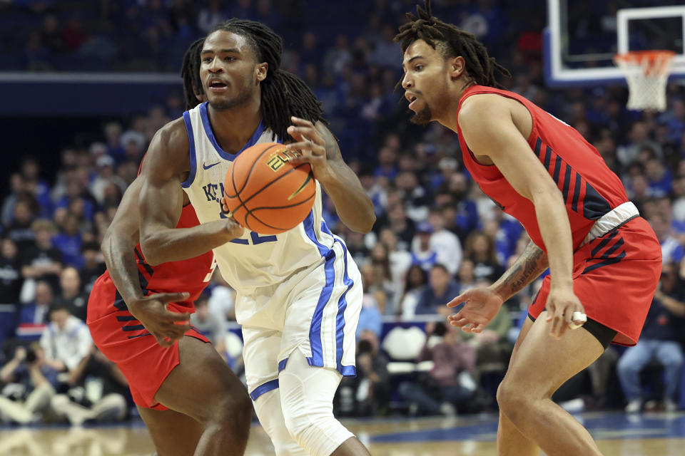 Kentucky's Cason Wallace (22) splits a pair of Duquesne defenders during the first half of an NCAA college basketball game in Lexington, Ky., Friday, Nov. 11, 2022. (AP Photo/James Crisp)