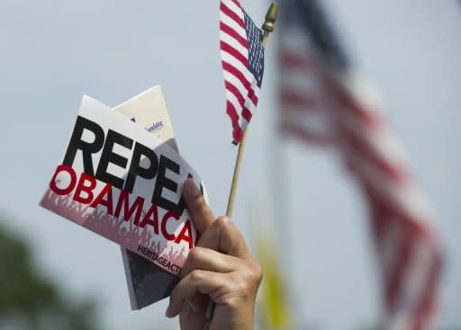 An opponent of US President Barack Obama's signature healthcare legislation protetstst a decision by the US Supreme Court on the constitutionality of the Affordable Healthcare Act, outside the Supreme Court in Washington, DC, June 28. Obama claimed a "victory" for all Americans after the Supreme Court upheld his reforms to extend health insurance to another 32 million citizens