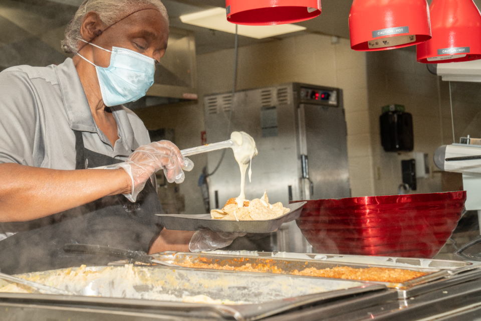 Eldoreatha Franklin slops nacho cheese on a tray at Mason/Clarke Middle School in East St. Louis, Ill. on Aug. 28, 2023. East St. Louis District 189 is one out of 18 public school districts in the metro-east providing free breakfast and lunches to all students.