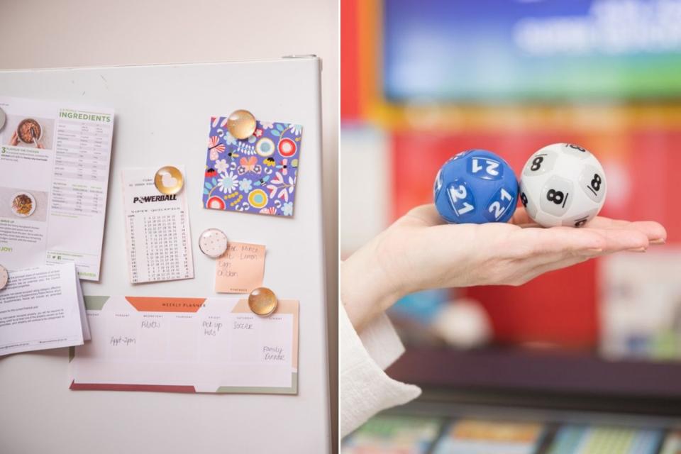 Winning Powerball ticket on fridge; Woman's hand holding two Powerball balls