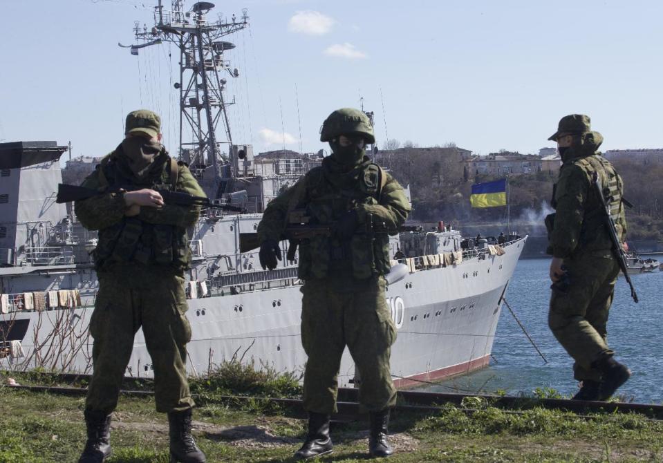 Russian soldiers guard a peer where two Ukrainian naval vessels are moored, in Sevastopol, Ukraine, on Wednesday, March 5, 2014. Ukraine's new prime minister said Wednesday that embattled Crimea must remain part of Ukraine, but may be granted more local powers. Since last weekend, Russian troops have taken control of much of the peninsula in the Black Sea, where Russian speakers are in the majority. (AP Photo/Ivan Sekretarev)