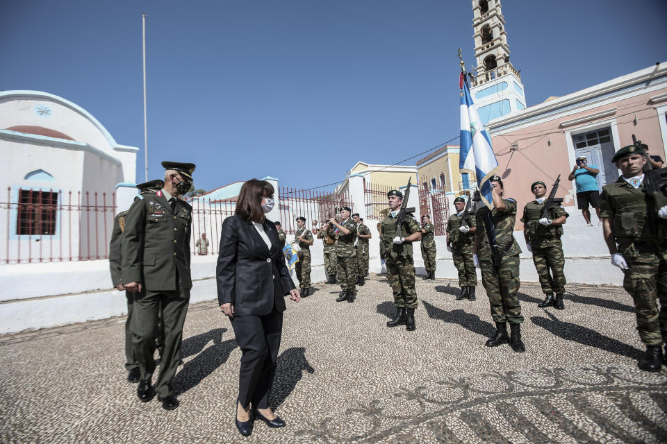 In this photo provided by the Greek President's office on Sunday, Sept. 13, 2020, Greece's President Katerina Sakellaropoulou inspects a guard of honour during celebrations marking when the southeastern island of Kastellorizo, formally became part of Greece. Greece's prime minister outlined plans Saturday to upgrade the country's defense capabilities, including purchasing new fighter planes, frigates, helicopters and weapons systems amid heightened tensions with Turkey over rights to resources in the eastern Mediterranean. (Thodoris Manolopoulos/Greek President's Office via AP)