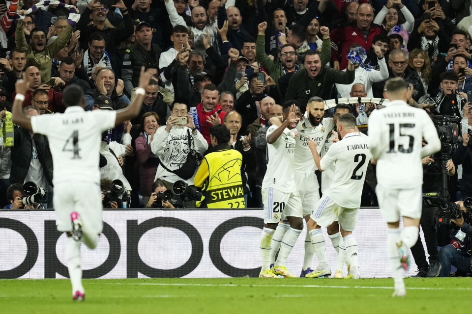 Real Madrid's Karim Benzema, right, celebrates with teammates after scoring the opening goal during the Champions League quarter final first leg soccer match between Real Madrid and Chelsea at Santiago Bernabeu stadium in Madrid, Wednesday, April 12, 2023. (AP Photo/Jose Breton)
