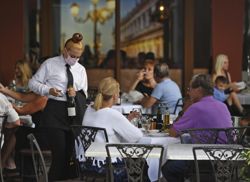 Diners and a server at a restaurant.