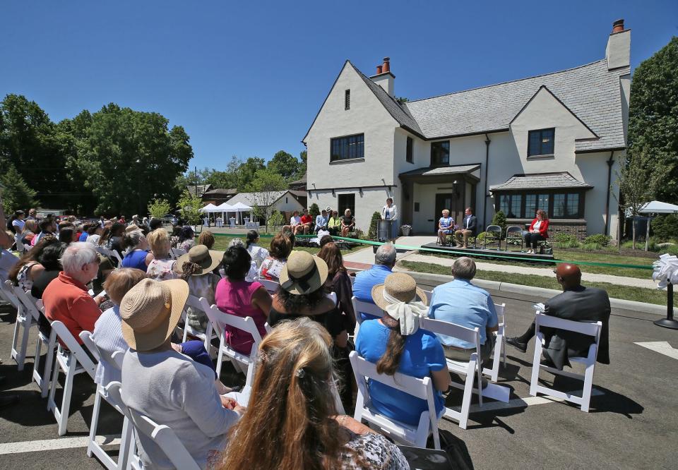 Attendees listen to the speakers at the ribbon-cutting ceremony for the Summit County Land Bank's new offices at the former home of John S. Knight in Akron on Friday.