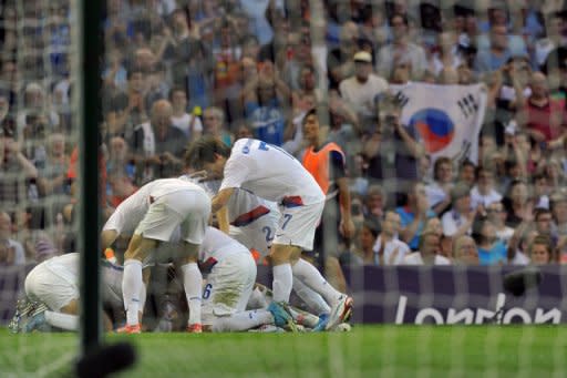 Korea's forward Park Chuyoung (C) celebrates with teammates after scoring the first goal against Japan during their London 2012 Olympic Games football bronze medal match, on August 10, at the Millenium stadium in Cardiff. S.Korea won 2-0