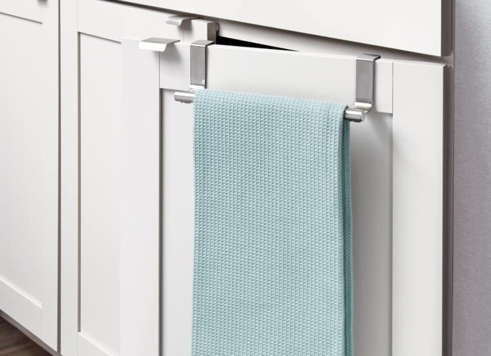 Blue dishtowel on over the cabinet hook on a white cabinet