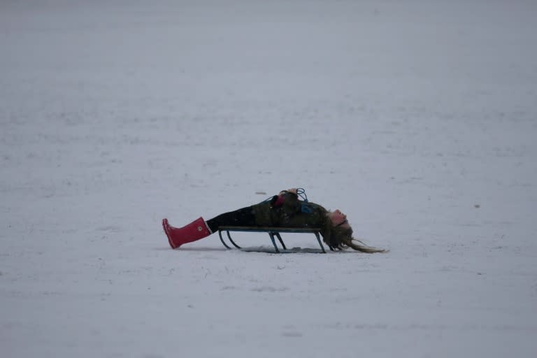 Some embraced the wintry conditions, like this woman taking a break on a sled in Hampshire, southern England