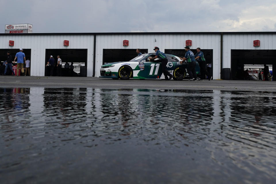 Crew members push the car of Daniel Hemric through the garage area during inspections for Saturday's NASCAR Xfinity Series auto race at Pocono Raceway, Friday, July 22, 2022, in Long Pond, Pa. (AP Photo/Matt Slocum)