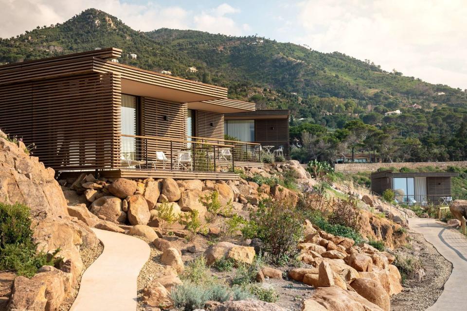 modern cliffside suites in Sicily's countryside with mountains in the background