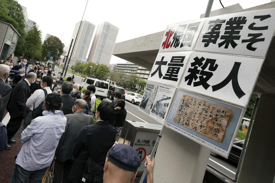 Plaintiffs and their supporters gather to walk toward the Tokyo District Court Thursday, Oct. 14, 2021, in Tokyo. The court is hearing five ethnic Korean residents of Japan and a Japanese national demanding the North Korean government pay compensation over their human rights abuses in that country after joining a resettlement program there that promised a “paradise on Earth,” but without the presence of a defendant - the North’s leader. The banner reads: "North Korea's 'Paradise on Earth' campaign is mass murder." (AP Photo/Eugene Hoshiko)