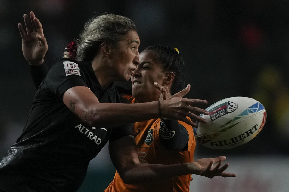 New Zealand's Sarah Hirini passes the ball as she is tackled by Australia's Sariah Paki during the final match in the Hong Kong Sevens rugby tournament in Hong Kong, Sunday, April 2, 2023. (AP Photo/Louise Delmotte)