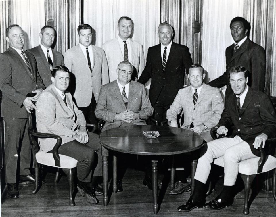 1969: Ohio State football coaching staff. Seated: John Mummey, left, Woody Hayes, Dave McClain, and Dick Walker. Standing: Earle Bruce, left, Lou McCullough, George Chaump, Esco Sarkkinen, Hugh Hindman and Rudy Hubbard.