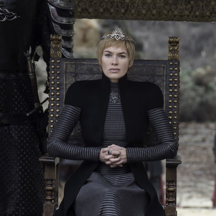 Lena Headey sits on a throne