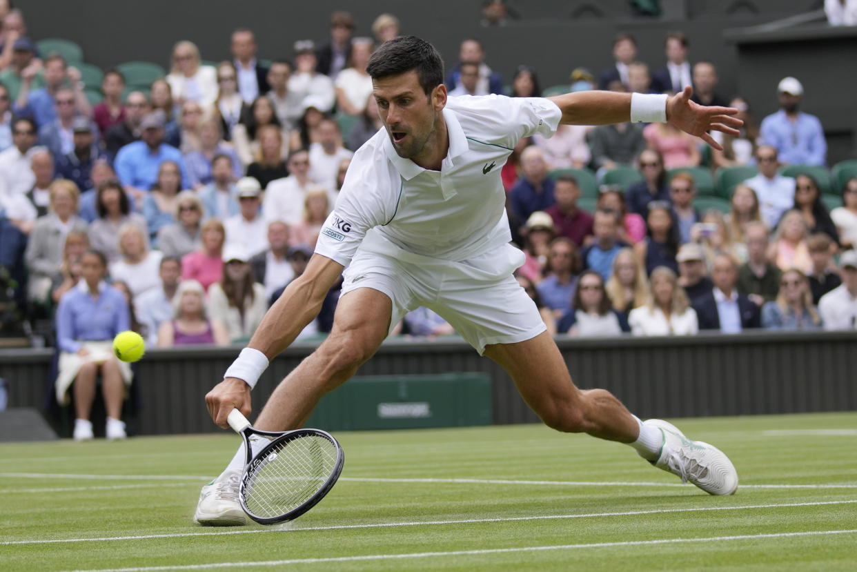 Serbia's Novak Djokovic plays a return to Hungary's Marton Fucsovics during the men's singles quarterfinals match on day nine of the Wimbledon Tennis Championships in London, Wednesday, July 7, 2021.(AP Photo/Kirsty Wigglesworth)