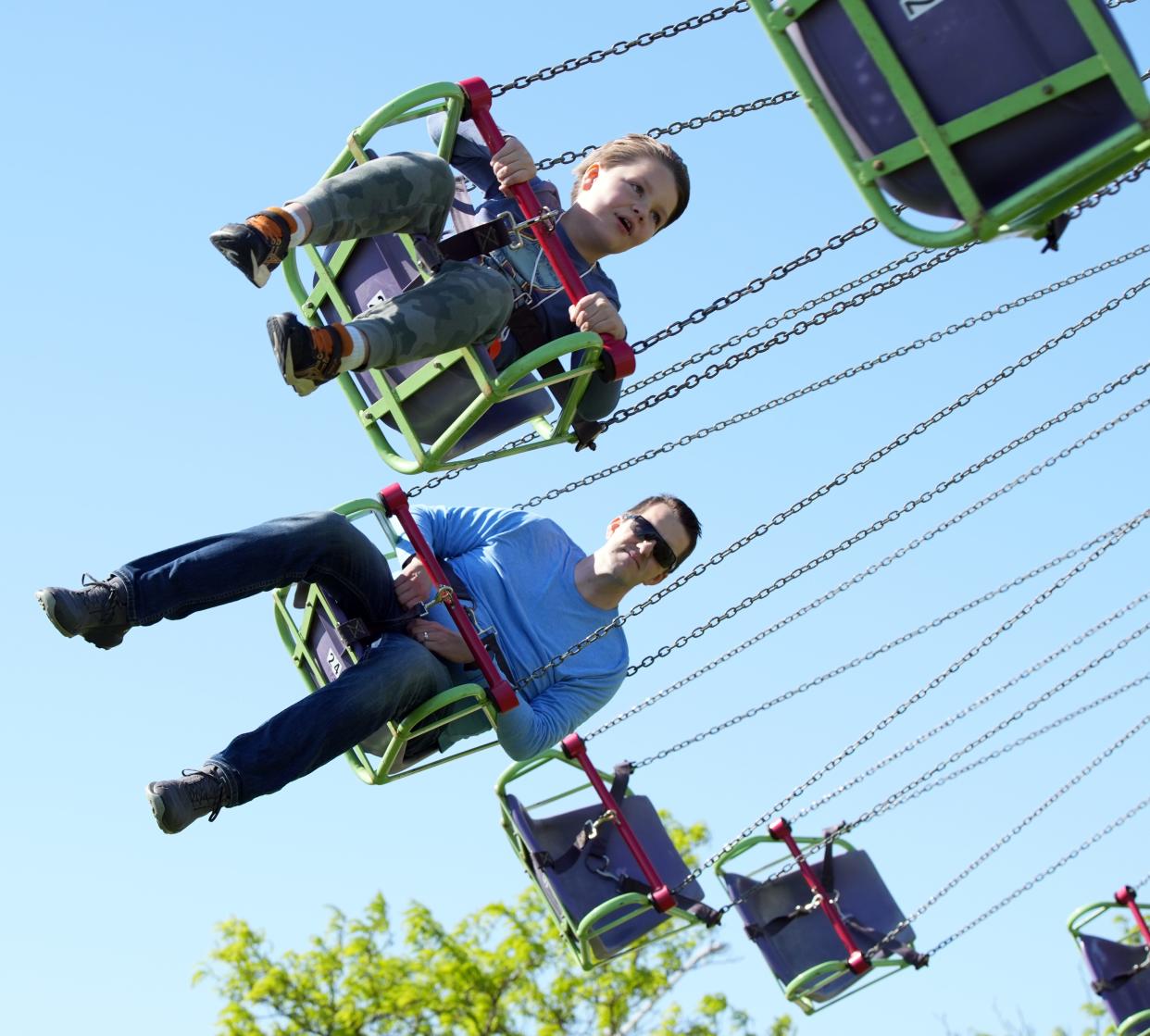 Wes Benninger and his son Ian, 8, ride the Zumur carnival ride at the Great Lawn during Thunder Over Louisville on Saturday, April 20, 2024.