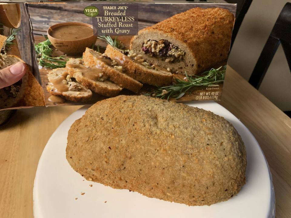 Trader joe's box of vegan roast behind cooked roast on wooden table