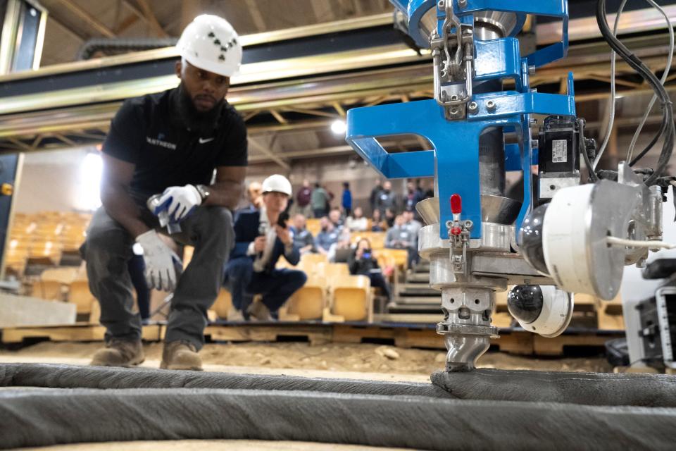 Apr 6, 2023; Columbus, Ohio, USA;  Bryant Youngblood, left, with Pantheon Innovative Builders, monitors Ohio’s first construction 3D printer during a foundation building demonstration at Plumb Hall in Columbus, Ohio on Thursday afternoon. Mandatory Credit: Joseph Scheller-The Columbus Dispatch
