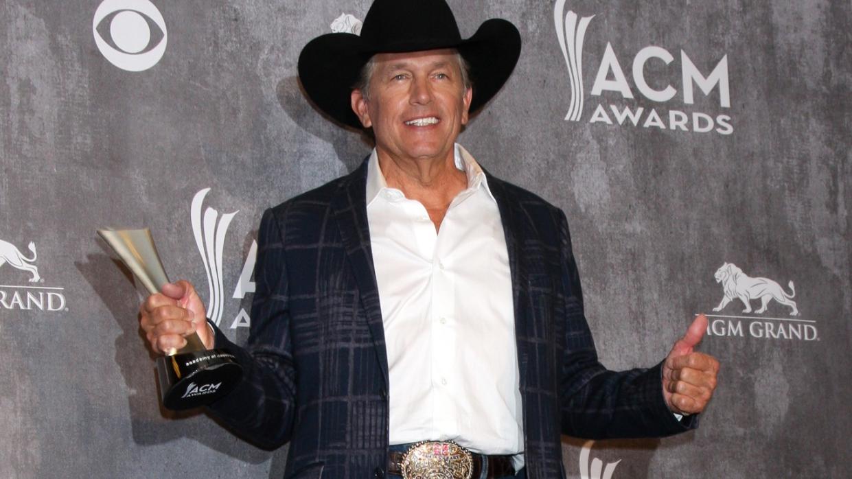 George Strait holding ACM Award red carpet