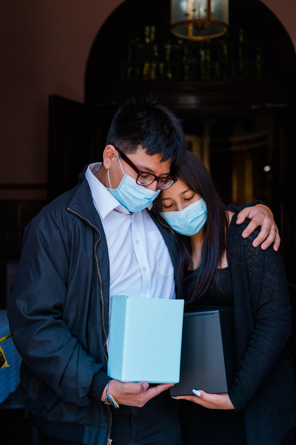 Luis Barrera, de 19 años, y su hermana Jessica, de 16, sostienen las cenizas de sus padres, quienes fallecieron a causa de COVID-19, durante una misa en la Iglesia del Santísimo Sacramento en Nueva York, 4 de julio de 2020. (Gabriela Bhaskar/The New York Times)