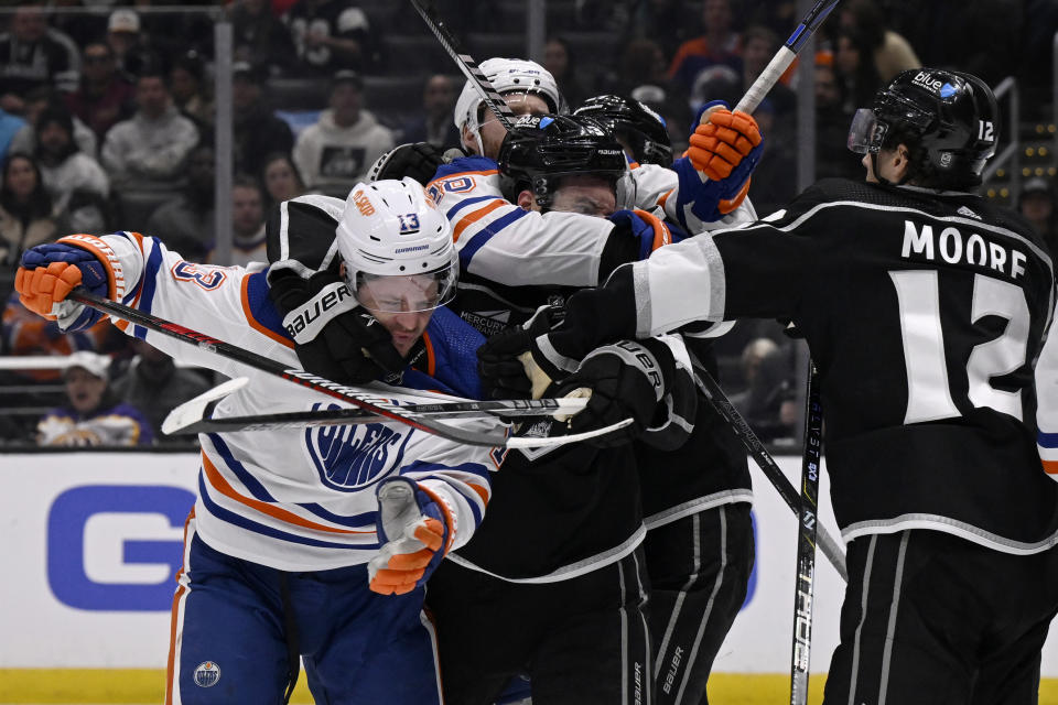 Edmonton Oilers center Mattias Janmark (13) fights with Los Angeles Kings left wing Trevor Moore (12), as Kings defenseman Matt Roy, center, is in a headlock by Oilers right wing Connor Brown (28) during the third period of an NHL hockey game in Los Angeles, Saturday, Feb. 10, 2024. (AP Photo/Alex Gallardo)