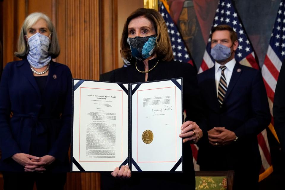 masked nancy pelosi holds giant folio with two masked people and american flags behind her