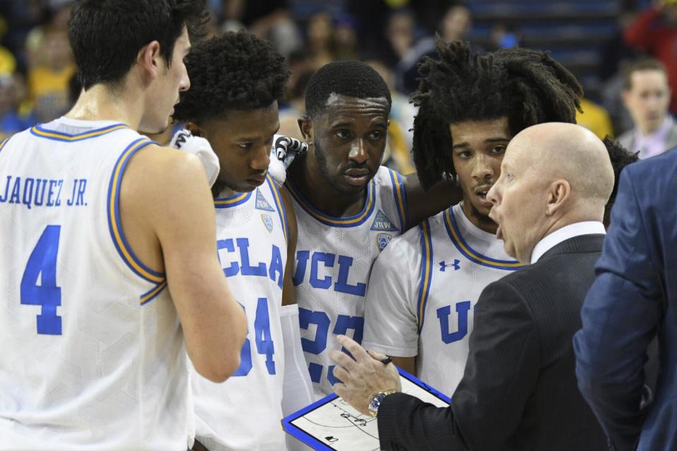 UCLA coach Mick Cronin talks with Jaime Jaquez Jr., David Singleton, Prince Ali and Tyger Campbell during a timeout