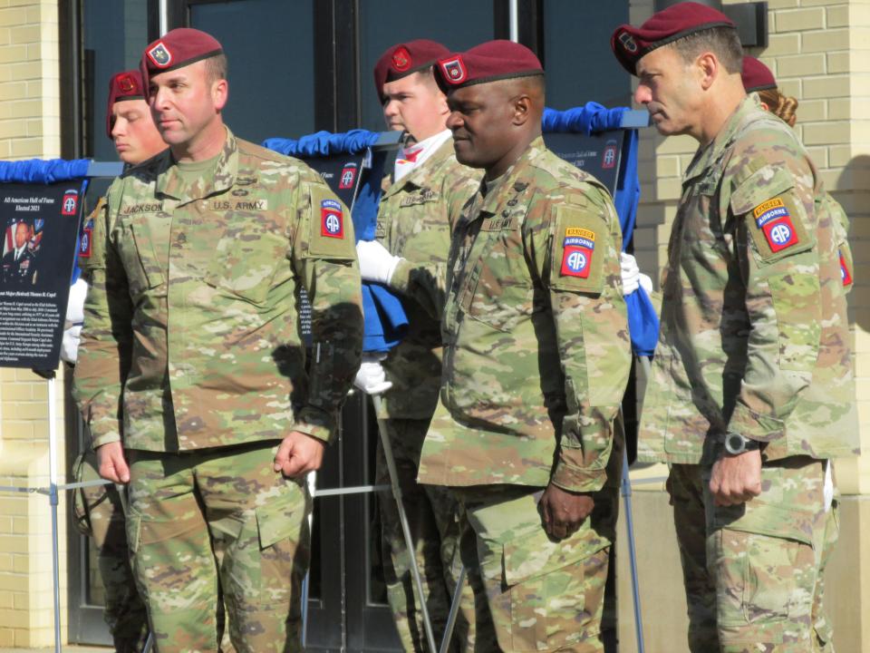 Staff Sgt. Jackson stands in to represent Pfc. Albert B. Dravland, who was named to the 82nd Airborne Division's Hall of Fame during a Nov. 19, 2021, ceremony at Fort Bragg. Also shown are the division's command team, Command Sgt. Maj. David Pitt and Maj. Gen. Christopher Donahue.