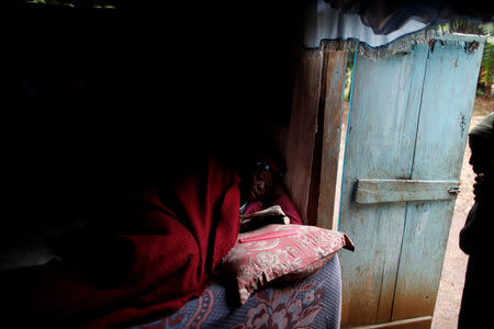 Dalina Paul lies on a bed reading, as her sister looks from the doorframe at their house in Boucan Ferdinand, Haiti, October 9, 2018. REUTERS/Andres Martinez Casares