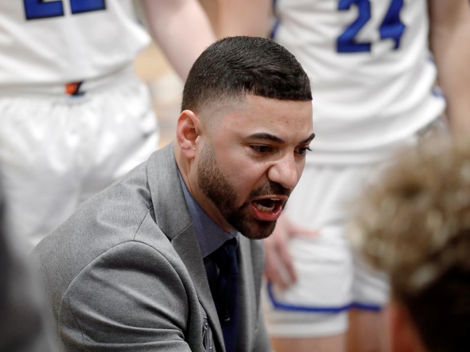 Zanesville coach Cedric Harris talks with his team during a timeout on Saturday night against visiting Cambridge. Zanesville won, 46-44, to earn its fourth straight victory.