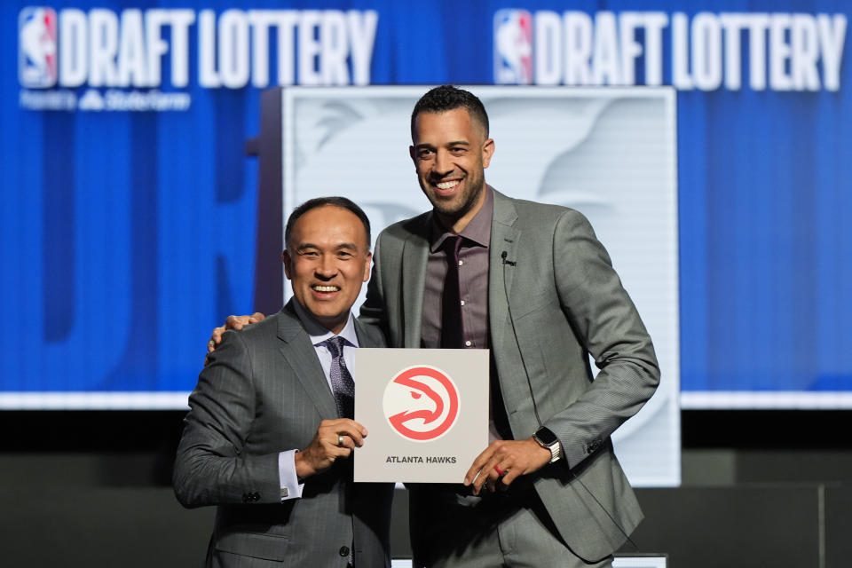 Atlanta Hawks general manager Landry Fields, right, and NBA deputy commissioner Mark Tatum pose for photos after Tatum announced that the Hawks had won the first pick in the NBA draft during the lottery drawing in Chicago, Sunday, May 12, 2024. (AP Foto/Nam Y. Huh)