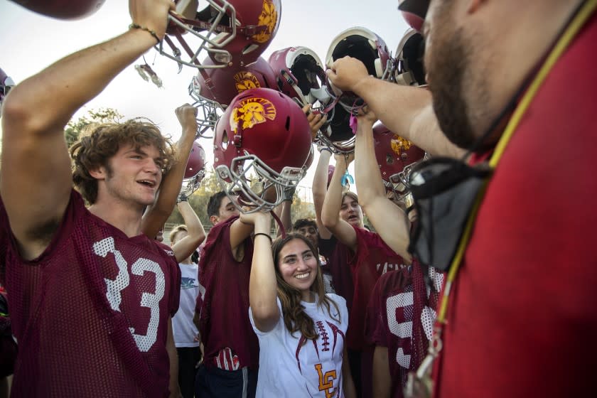 Kicker Shaina Clorfeine huddles with La Canada teammates and head coach Dave Avramovich, right, during the end of practice.