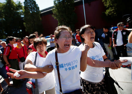 FILE PHOTO: Family members of passengers onboard the missing Malaysia Airlines Flight MH370, cry as they gather to pray Yonghegong Lama Temple in Beijing September 8, 2014, on the six-month anniversary of the disappearance of the plane. REUTERS/Kim Kyung-Hoon/File Photo