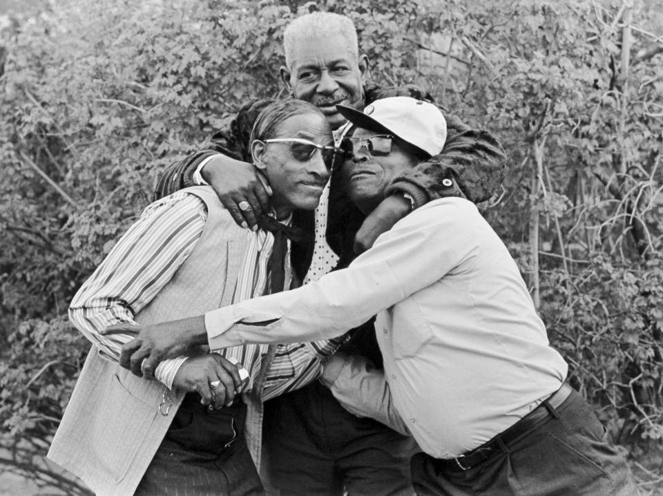 This image provided by the estate of Dick Waterman, shows Arthur Crudup, center, with Fred McDowell, left, and Robert Pete Williams. Crudup wrote the song “That’s All Right,” which Elvis Presley later recorded for his first single. But Crudup received scant songwriting royalties because a record contract funneled the money to his original manager. Crudup died in 1974, leaving behind one of the starker accounts of Black-artist exploitation in the 20th Century. (Dick Waterman via AP)