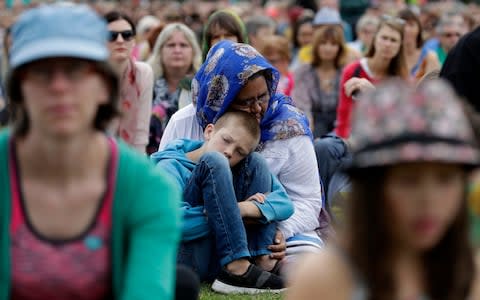 A woman embraces a boy at the "March for Love"  - Credit: Mark Baker/AP