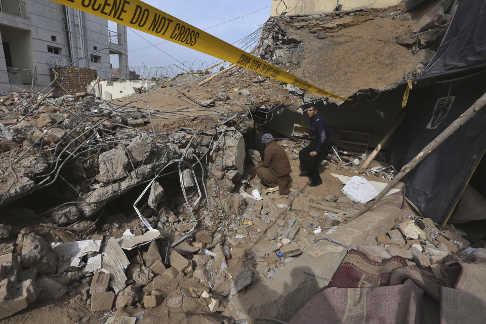 People view damage at the site of Monday's suicide bombing, in Peshawar, Pakistan, Feb. 2, 2023. A suicide bomber who killed 101 people at a mosque in northwest Pakistan this week had disguised himself in a police uniform and did not raise suspicion among guards, the provincial police chief said on Thursday. (AP Photo/Muhammad Sajjad)