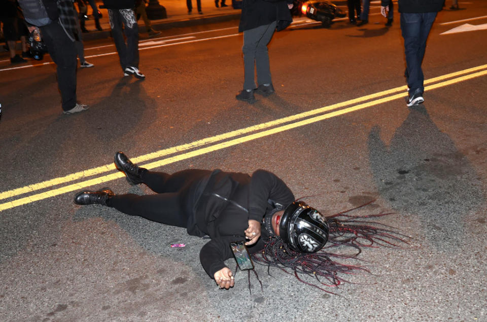 A Black Lives Matter protester bleeds from the mouth as she lays in the middle of the street. Source: Getty