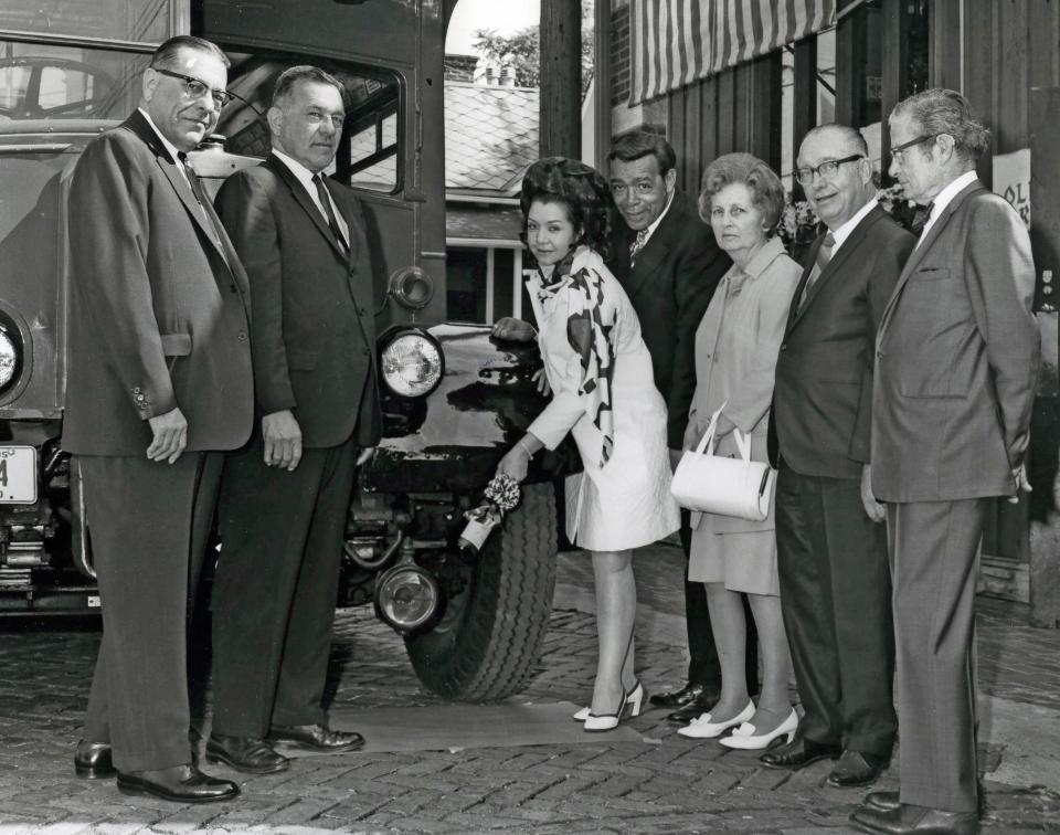 Columbus city officials including Public Utilities Director, William H. Brooks and his wife Mary Adams Brooks, christen a new city vehicle.