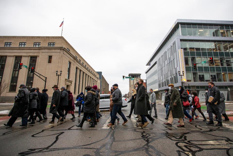 Guests and public officials march from the County City Building to the Rev. Theodore M. Hesburgh and Rev. Martin Luther King Jr. Statue Monday, Feb. 17, 2022 in downtown South Bend. More than 50 people gathered for prayer at the County City Building before marching to the downtown. The abbreviated march was held despite the full slate of MLK Day activities being rescheduled to Feb. 21 due to COVID-19 concerns. 