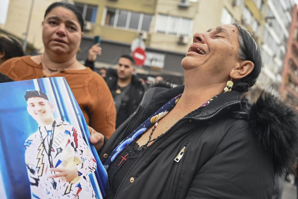 FILE - A woman reacts as she holds a photo of an injured 16-year-old teenager while relatives and other protesters from the Roma community protest outside the courthouse in Greece's second largest city of Thessaloniki, on Friday, Dec. 9, 2022. The 16-year-old Roma teenager, who was shot in the head during a police chase over an allegedly unpaid gas station bill, has died on Tuesday, Dec. 13, 2022, after been hospitalized for more than a week in Thessaloniki. (AP Photo/Giannis Papanikos, File)