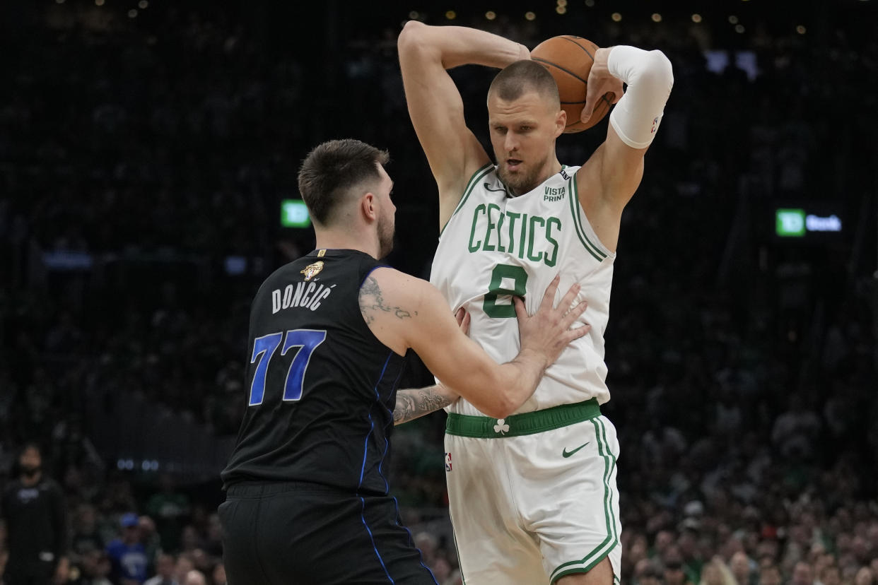 Boston Celtics center Kristaps Porzingis (8) waits to drive against Dallas Mavericks guard Luka Doncic during Game 1 of the NBA Finals basketball series, Thursday, June 6, 2024, in Boston. (AP Photo/Charles Krupa)