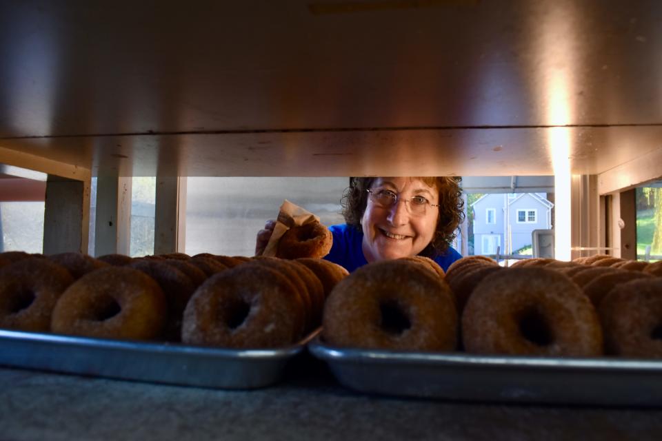 Jeannine Ridgeway grabs a cider doughnut from a display at Tantillo's Farm Market in Gardiner.