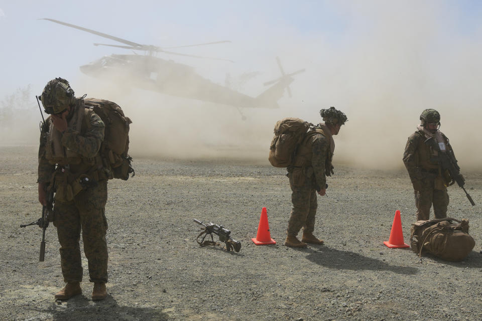 U.S. troops takes cover from dust as a U.S .Army UH-60 Blackhawk helicopter prepares to land at Paredes Air Station at Pasuquin, Ilocos Norte province, during a joint military exercise in northern Philippines on Monday, May 6, 2024. American and Filipino marines held annual combat-readiness exercises called Balikatan, Tagalog for shoulder-to-shoulder, in a show of allied military readiness in the Philippines' northernmost town facing southern Taiwan. (AP Photo/Aaron Favila)