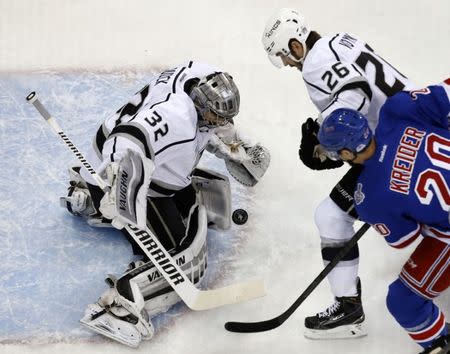 Los Angeles Kings goalie Jonathan Quick (L) makes a save on New York Rangers' Chris Kreider as King's Slava Voynov attempts to clear the front of the crease during the first period in Game 4 of their NHL Stanley Cup Finals hockey series in New York June 11, 2014. REUTERS/Shannon Stapleton