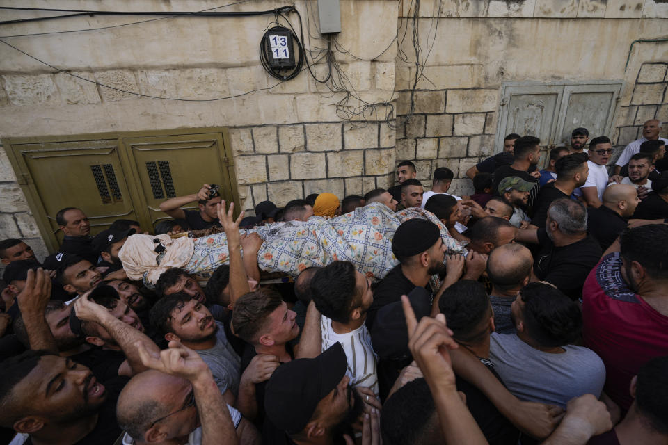 Palestinians carry the body of Islam Sabouh, who was killed during an operation by Israeli forces in the West Bank city of Nablus, Tuesday, Aug. 9, 2022. Israeli police said forces encircled the home of Ibrahim al-Nabulsi, who they say was wanted for a string of shootings in the West Bank earlier this year. They said al-Nabulsi and another Palestinian militant were killed in a shootout at the scene, and that troops found arms and explosives in his home. (AP Photo/Majdi Mohammed)