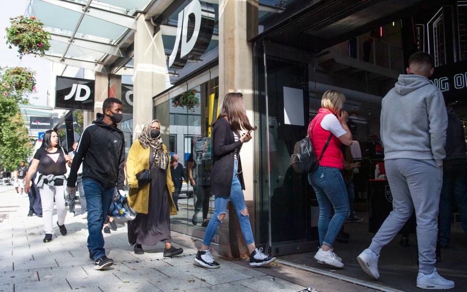 Queue of shoppers wait to enter JD Sports store in Cardiff on the first day of re-opening after the winter lockdown