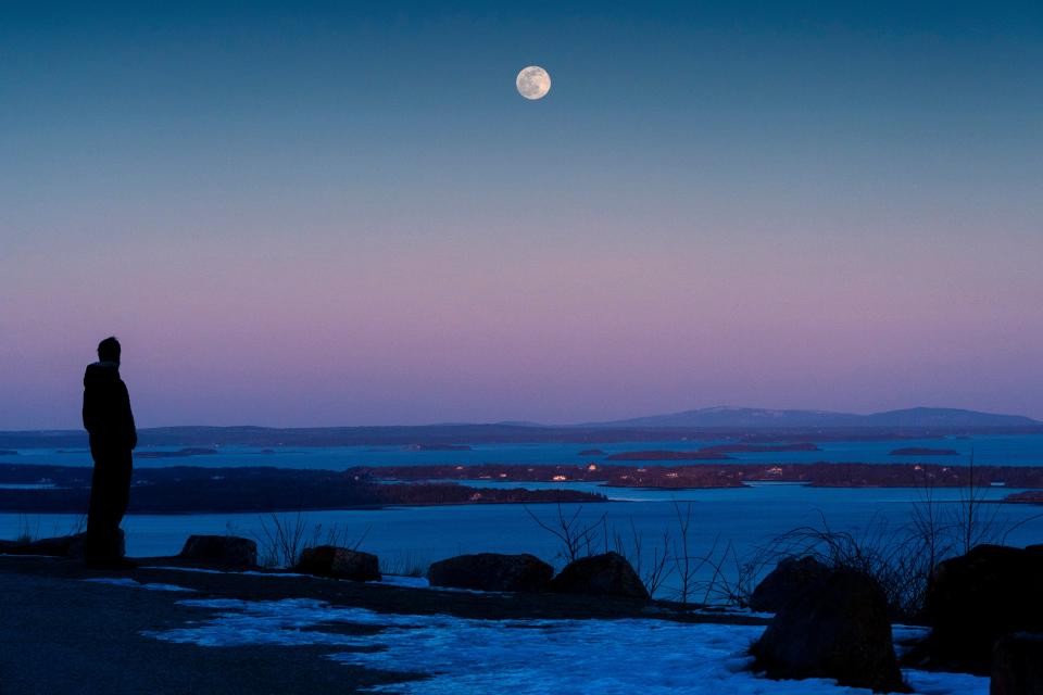 Shawn Griffith, of South Port, Maine, watches the “snow moon” rise in clear skies over Penobscot BayAP