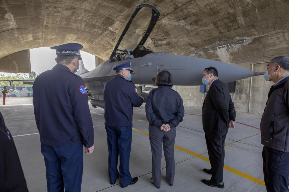 In this photo released by the Taiwan Presidential Office, Taiwan's President Tsai Ing-wen, center, accompanied by officials, looks at the F-16 fighter jet at a military base in Chiayi, southwestern Taiwan, Friday, Jan. 6, 2023. President Tsai visited a military base Friday to observe drills while rival China protested the passage of a U.S. Navy destroyer through the Taiwan Strait, as tensions between the sides showed no sign of abating in the new year. (Taiwan Presidential Office via AP)