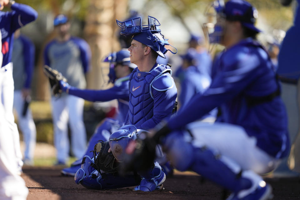 Los Angeles Dodgers catcher Will Smith, center, and other catchers participate in spring training baseball workouts at Camelback Ranch in Phoenix, Tuesday, Feb. 13, 2024. (AP Photo/Ashley Landis)