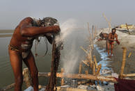 A Hindu Holy man smears ash on his hair after a holy dip at Sangam, the sacred confluence of the rivers Ganga, Yamuna and the mythical Saraswati, during Magh Mela festival, in Prayagraj, India. Tuesday, Feb. 16, 2021. Hindus believe that ritual bathing on auspicious days can cleanse them of all sins. A tented city for the religious leaders and the believers has come up at the sprawling festival site with mounted police personnel keeping a close watch on the activities. The festival is being held amid rising COVID-19 cases in some parts of India after months of a steady nationwide decline. (AP Photo/Rajesh Kumar Singh)